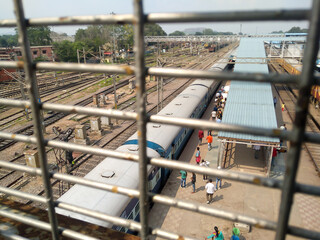 Naklejka premium Railway station view through Metal Frame Structure With Space Frame from Roof of a building. Cantonment railway station India South Asia Pac May 2019