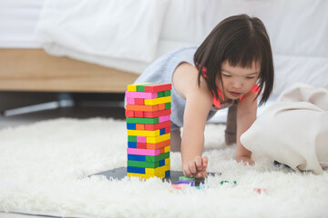 Little girl with learning disabilities Or the group of dow syndrome is learning about colorful wood toy with family teaching and encouraging beside. Education special concept.