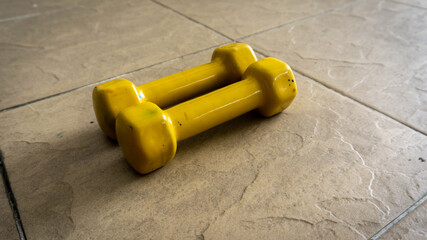 Pairs of 1 kilogram yellow mini dumbbells on the floor.