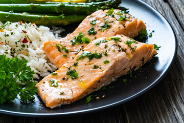 Steamed salmon fillet with basmati rice, asparagus and vegetables on wooden table