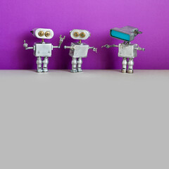 Simplified design robotic toys. Three metal silver robots on purple gray background. Two of the...