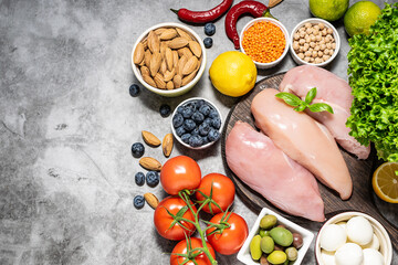 Assortment of fresh balanced food on dark stone background top view. Organic farmer’s goods. Food delivery concept.