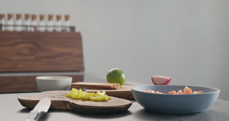 chopped yellow pepper on olive wood board for greek salad