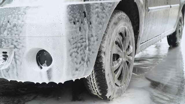 Close up clean car concept at car wash. Washing car with soap. Car wash