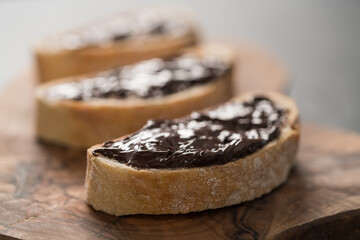 Rustic ciabatta with organic chocolate cream on olive wood board