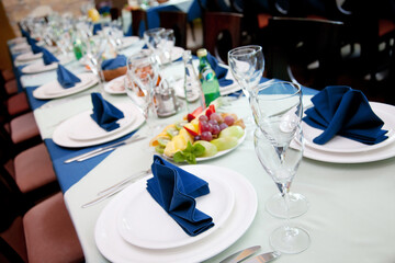 Restaurant table with empty wineglasses and plates for banquet or wedding dinner
