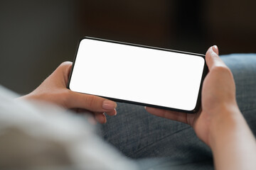Young woman hold smarphone with white screen while sitting in a chair