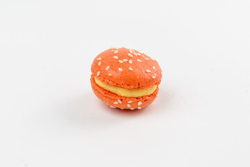 Mango-colored sweet macaroon on a white background