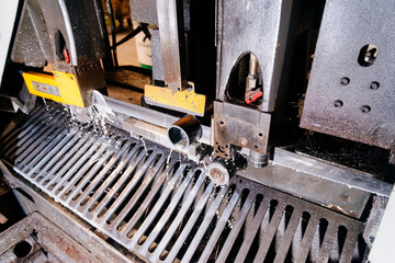 Metal cutting. The machine saws metal workpieces into parts. Sawing metal.