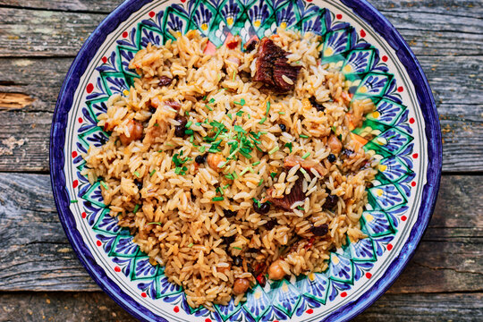 Classic Uzbek pilaf with lamb and chickpeas in a national plate Healthy food