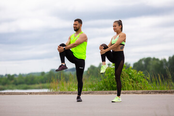 Athletic guy and girl fitness trainer do pilates together on street. Healthy sport lifestyle. Photography for ad or blog