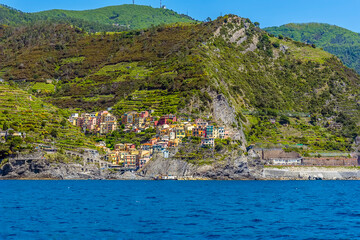 Fototapeta premium A view from the sea towards the Cinque Terre village and station of Manarola, Italy in the summertime