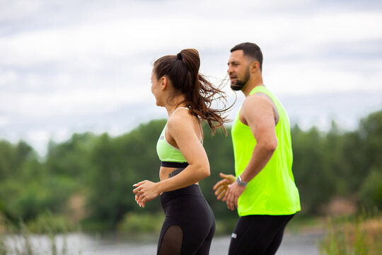 Athletic couple girl and man in stylish sportswear run in nature, photo for blog and ad of sport and healthy lifestyle