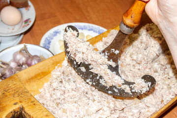 Chop aspic, aspic from meat with a hoe in an old wooden trough. Russian old village traditions for holidays.