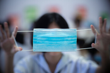 Close up to face mask in hands of uniform student