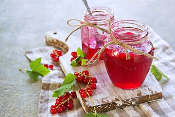 Homemade  red currant  jam in curly jar  on a light gray concrete background.  Jam recipes. Harvest berries.