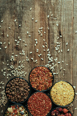 Mix of spices in bowls and sunflower seeds on wooden table. Close up photography for food blog or poster 