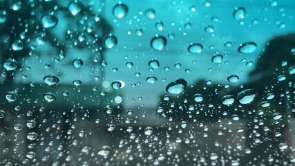 Blurred view,raindrop on windshield,colorful bokeh with street light at rainy day,dimly light.Drive car on street in heavy rainstorm.