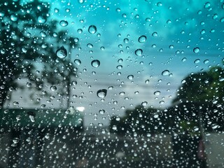 Blurred view,raindrop on windshield,colorful bokeh with street light at rainy day,dimly light.Drive car on street in heavy rainstorm.