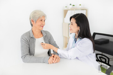 Fototapeta premium Asian doctor talk with old female patient about disease symptom, doctor use stethoscope listening lung of patient, elderly health check up, happiness hospital