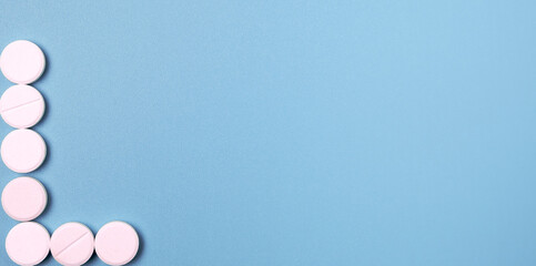 Close up of many white pills on blue background.