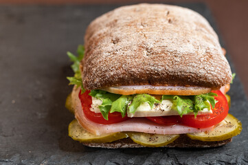 A sandwich with various fillings. Angled front view.