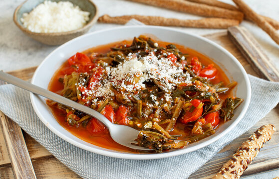 Healthy Sauteed green cicory and tomatoes topped with caccioricotta cheese