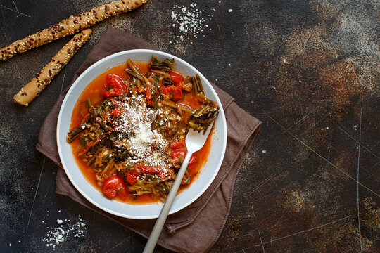 Healthy Sauteed green cicory and tomatoes topped with caccioricotta cheese