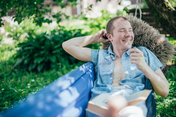 A man is resting and reading in a hammock. Day off and relaxation