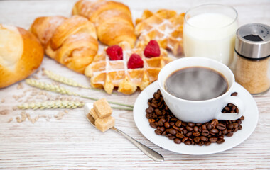 Breakfast in the morning with black coffee cup with bread with Croissant and fruit on the wooden table.