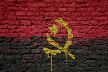 painted big national flag of angola on a massive old brick wall - obrazy, fototapety, plakaty
