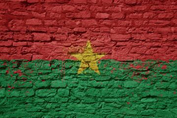 painted big national flag of burkina faso on a massive old brick wall