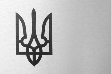 black coat of arms of Ukraine on the gray metal background. trident – the national symbol of Ukrainian people - obrazy, fototapety, plakaty