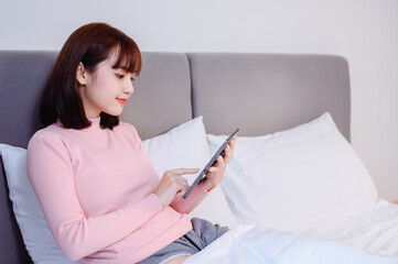 Asian woman work online and relax in bedroom at home. Social Distancing and New normal daily...