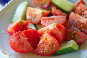 white plate with sliced tomatoes and cuccumber