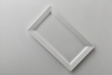 Top view shot of a rectangular white plate on white background.