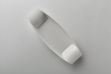 Top view shot of a rectangular white plate on white background.