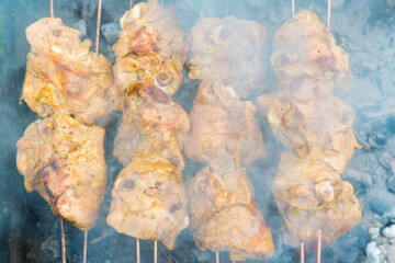 Cooking chicken on the grill. smoke. Marinated shashlik preparing on a barbecue grill over...