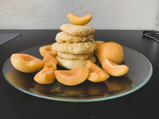 Cheesecakes with fresh apricots in a glass plate on a black table. Good nutrition. Delicious and healthy Breakfast.
