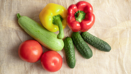 Summer set of vegetables. Ripe yellow and red bell peppers, cucumbers, tomatoes, zucchini. Soft fabric