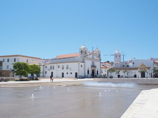 Fototapeta na wymiar Wasserbassin, Platz der Republik und Kirche Santa Maria in Lagos Portugal