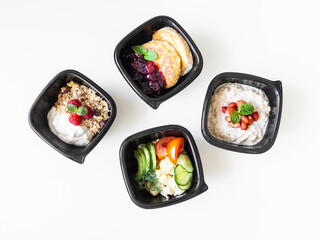 Healthy breakfast delivery. Fitness food. Eat right concept, healthy food, clean food take away in boxes, fried egg and vegetables, oatmeal, granola, cheesecakes on table close up