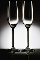 Two champagne glasses studio dark reflection
