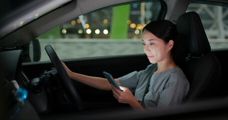 Woman use of mobile phone in car at night © leungchopan