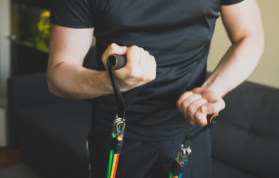 Man Doing Exercises With Resistance Bands At Home.