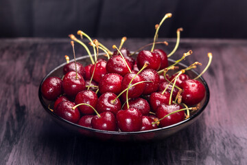 fresh sweet cherries in a bowl on a dark background