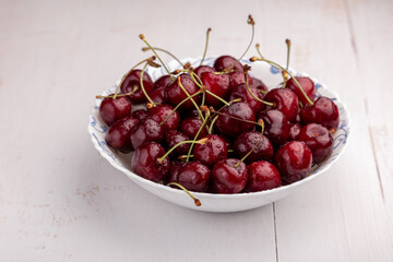 sweet cherries in a bowl on a wooden background