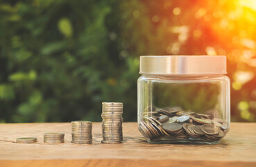 Piggy bank and stack of coins arranged together On an old wooden table