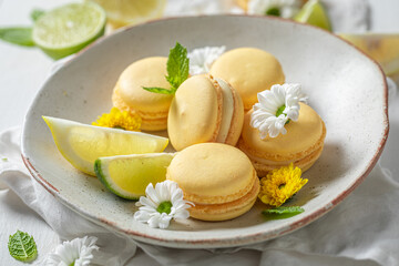 Homemade lemon macaroons on white table with spring flowers