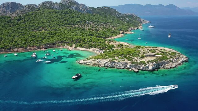 Aerial drone video of secluded paradise bay and small island of Moni with turquoise crystal clear beach next to Aigina, Saronic gulf, Greece